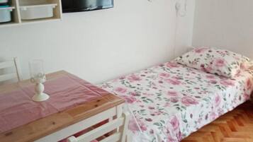 Tabla de planchar con plancha, internet y ropa de cama