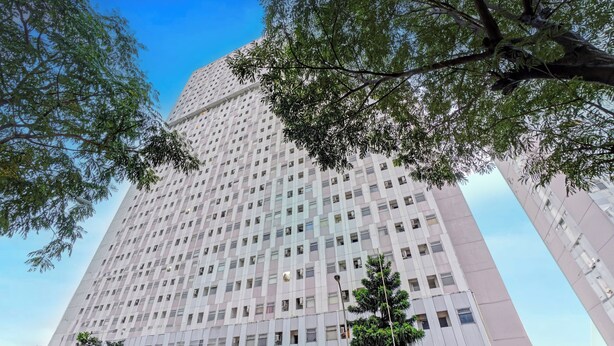 A tall, modern building with a grid of windows and a flat facade. - OYO 95064 Gunung Putri Skyland (Gunung Putri)