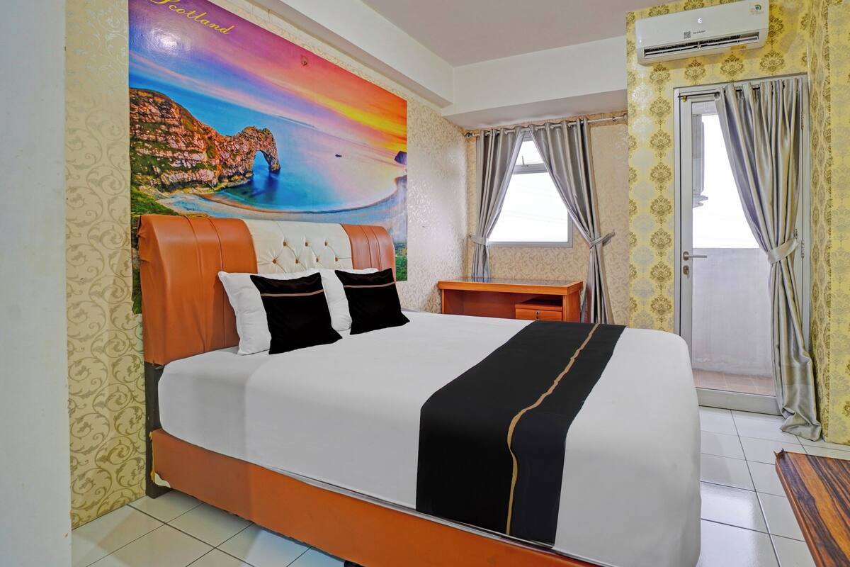 Ein Hotelzimmer mit einem großen Bett, einem Schreibtisch, einer Klimaanlage und Blick ins Freie.