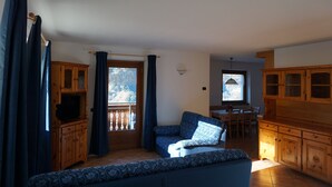A spacious living area with a sofa, wooden cabinets, and a dining table. - Baita la Malgheta - Bormio, mountains, skiing and relaxation (Piatta)