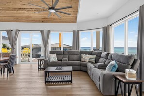 A modern living room with a sectional sofa, a coffee table, and a ceiling fan. - Amazing Beachfront Home, Incredible Views, Heated Pool, Hot Tub, Elevator! (Destin)