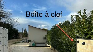 A construction site with a building under construction, a dirt path, and a hedge. - Charming exceptional house on the outskirts of Bordeaux (Eysines)