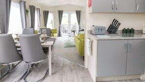 A modern kitchen with grey cabinets, a toaster, and a knife block. - The Haven (New Quay)