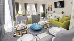 A dining area with a table set for four, including plates, glasses, and cutlery. - The Haven (New Quay)