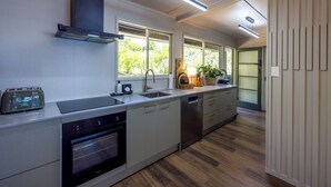 Una cucina moderna con forno integrato, lavastoviglie e un tostapane.