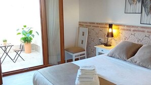 A bedroom with a bed, a chair, a table, and a potted plant. - CASA RURAL TOLANCA. Near Toledo and Puy du Fou (Sonseca)