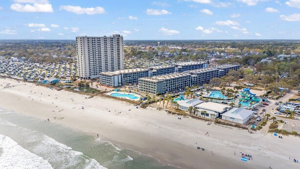 A coastal hotel with multiple buildings, a beach, and a swimming pool. - Sun & Fun | Beachfront Resort~Pool~Lazy River~Gym (Myrtle Beach)