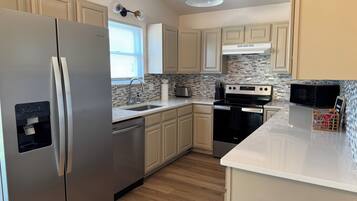 A modern kitchen with stainless steel appliances, a dishwasher, a microwave, and a stove.