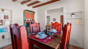 Un coin repas avec des chaises en bois et une table dressée pour deux, une porte rustique et un panneau indiquant la Route 66 accroché au mur.