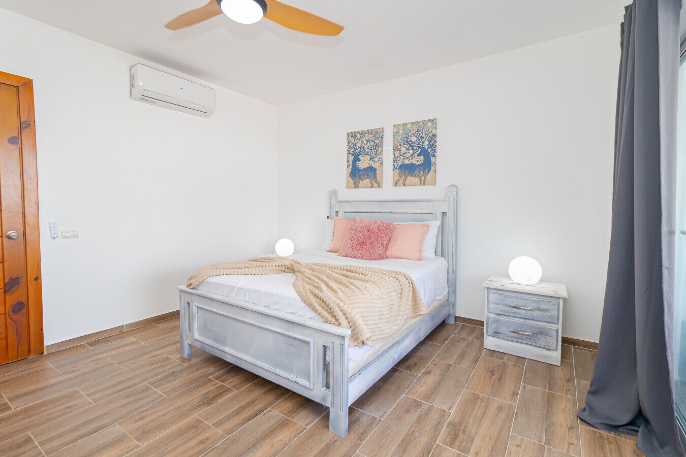 A bedroom with a bed, bedside tables, and a ceiling fan.