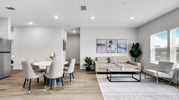 A modern living room with a dining area, a sofa, and a coffee table. - Beautiful 3BR Ocala Home | Perfect for Families (Ocala)