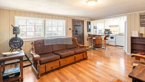 A cozy living room with a sofa, a wooden coffee table, and a vintage radio. - Family & Dog Oasis (Knoxville)