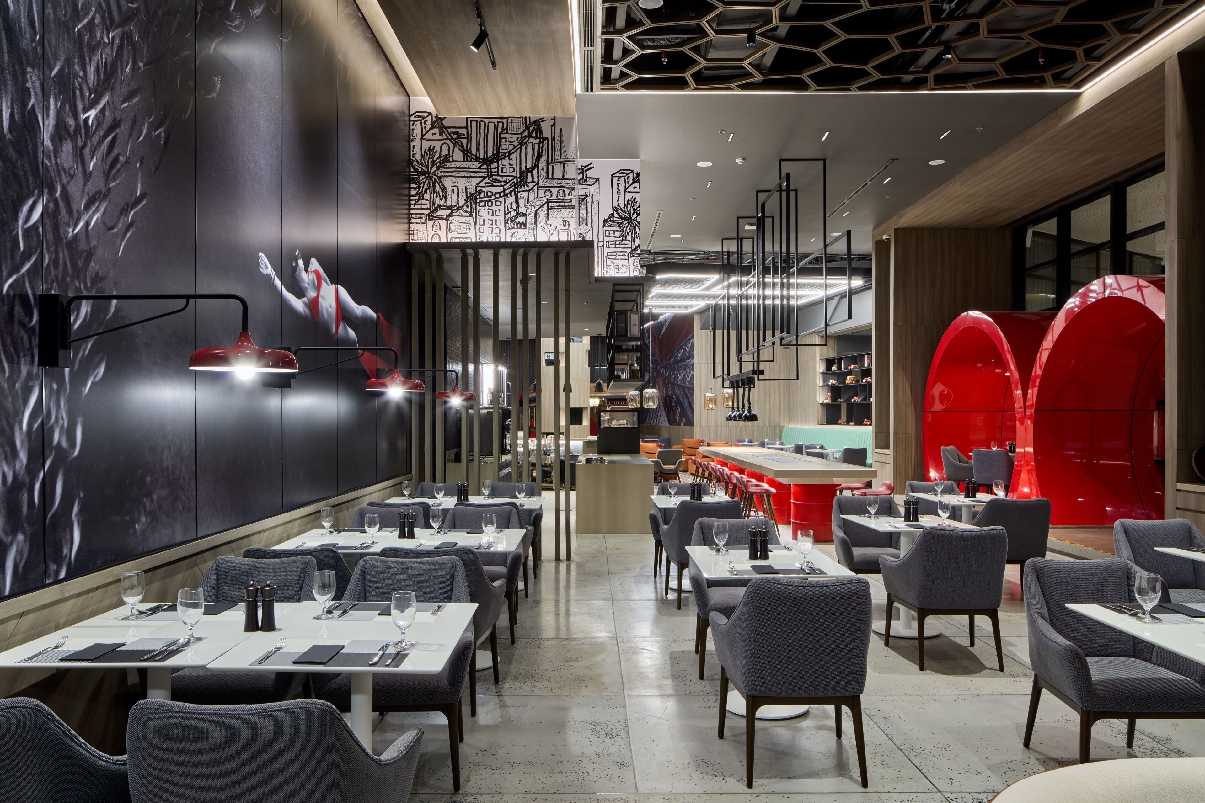 Un restaurante moderno con un amplio comedor, techos altos y decoración contemporánea.