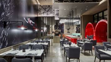 Un restaurante moderno con un amplio comedor, techos altos y decoración contemporánea.