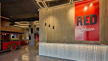 A reception area with a prominent RED sign, a modern design with wooden panels, and a unique seating area resembling a train.