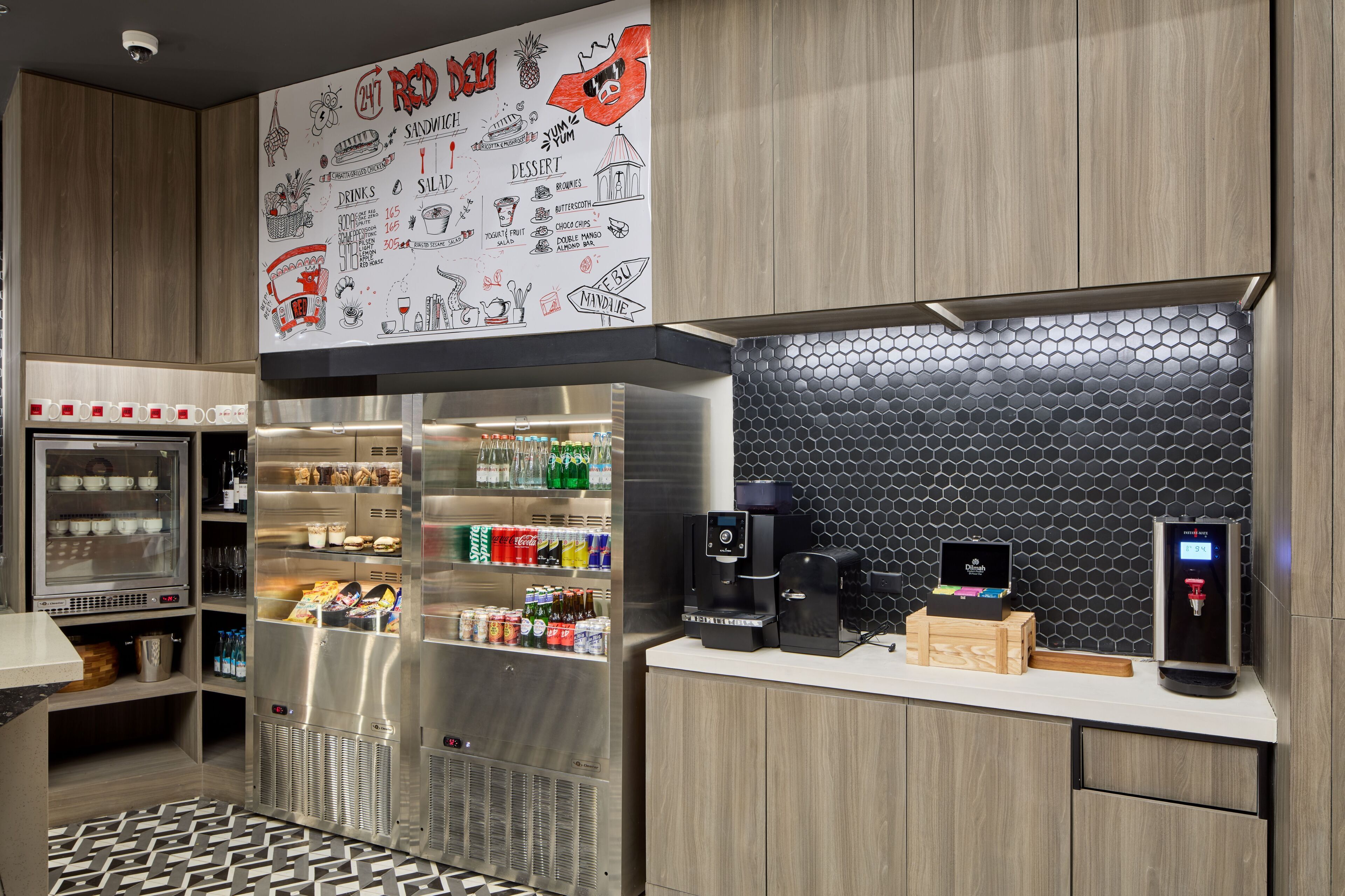 A modern kitchen with a coffee machine, a refrigerator, and a vending machine.