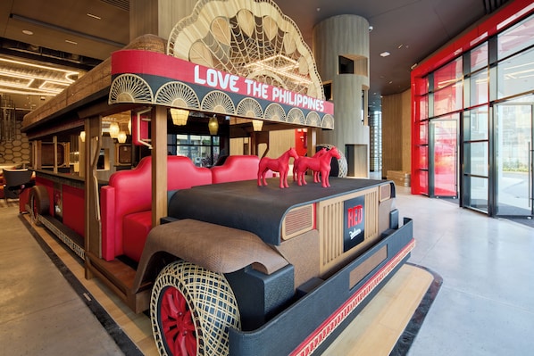 Un espace aménagé avec des meubles d’époque, agrémenté d’une enseigne sur laquelle on peut lire « J’AIME LES PHILIPPINES » et surmonté d’un auvent décoratif.