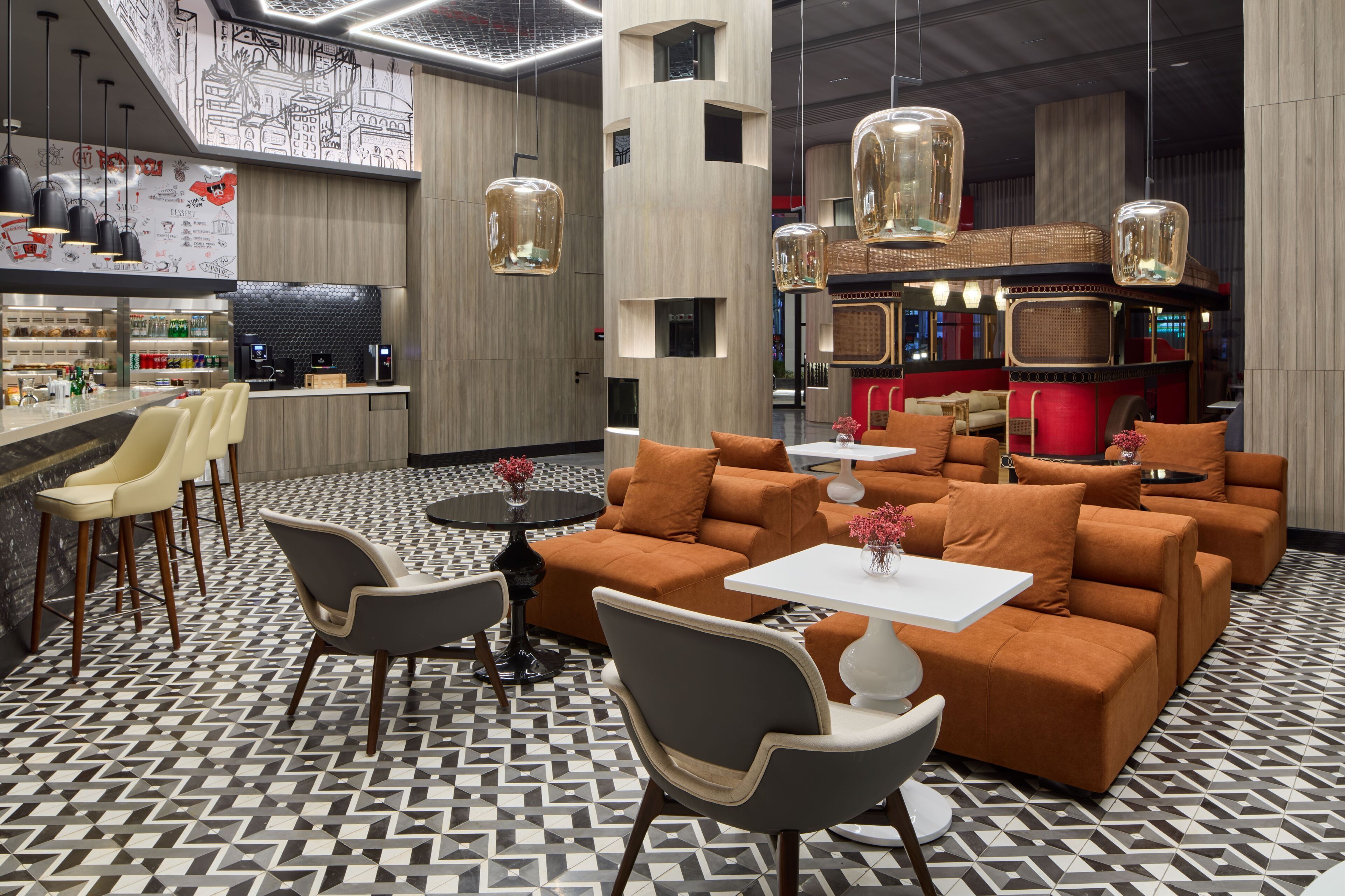 A modern bar area with seating, a kitchen, and a unique wall design.