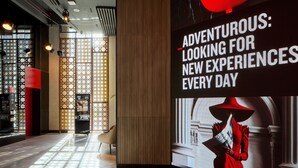 A modern interior with a large digital display advertising 'ADVENTUROUS: LOOKING FOR NEW EXPERIENCES EVERY DAY.' - Radisson RED Cebu Mandaue (Mandaue)
