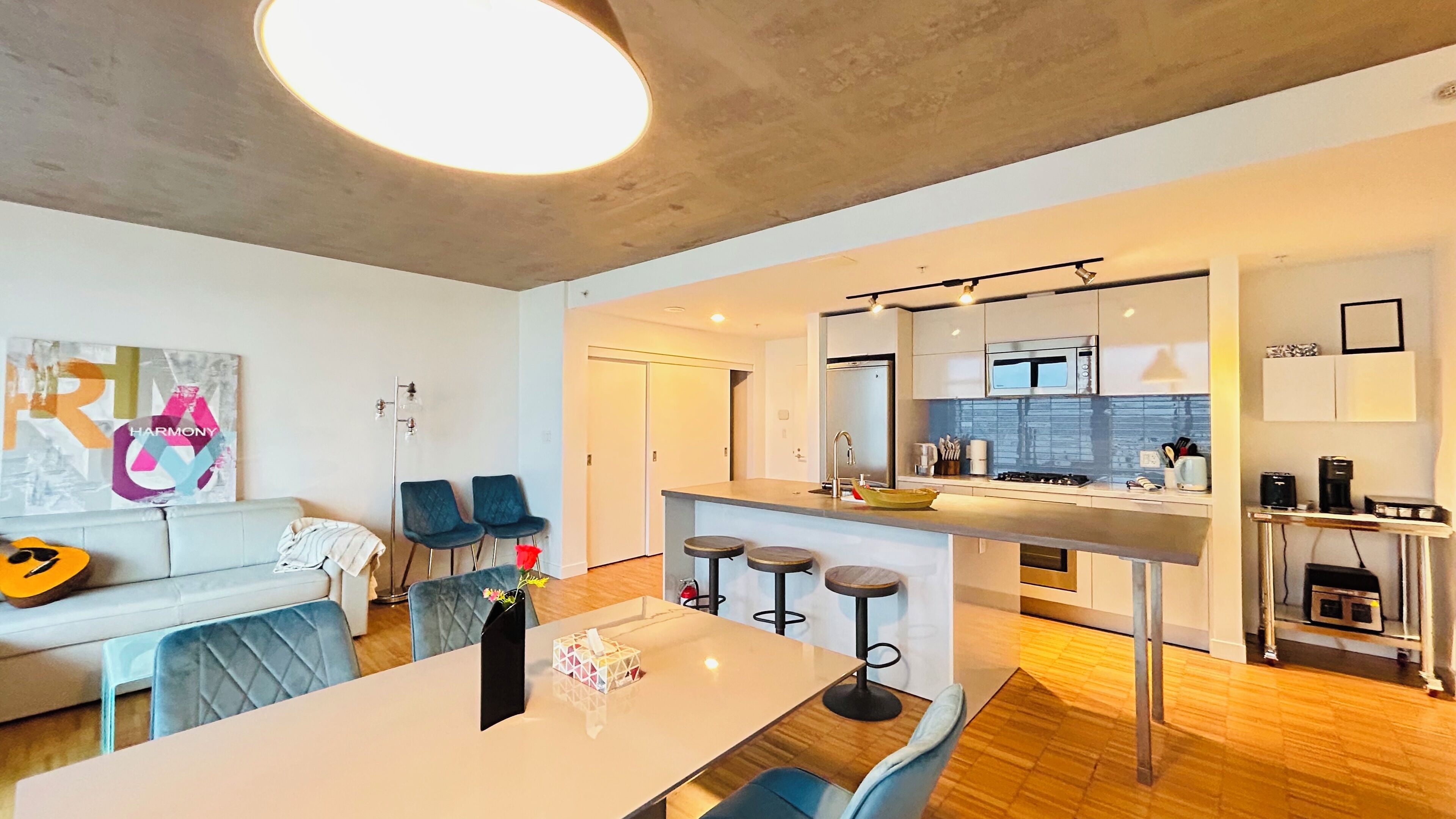 A modern apartment with a dining area, kitchen, and living space.