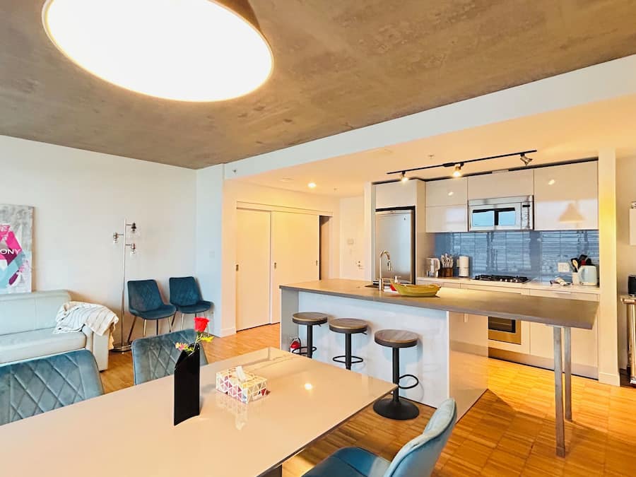 A modern apartment with a dining area, kitchen, and living space.