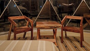 Una carpa con un diseño geométrico en la ventana, muebles de madera y una alfombra a rayas.