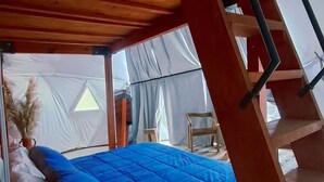 A tent with a bed, a ladder, and a small table. - Cúpula de pequeños exploradores de GEstores (Amealco de Bonfil)