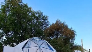 A geodesic dome structure with a netted enclosure in front. - Cúpula de pequeños exploradores de GEstores (Amealco de Bonfil)