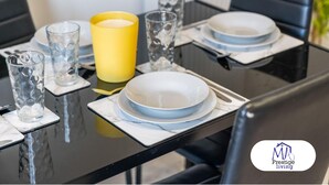 A dining table set with plates, glasses, and a candle. - Central Home | Fast Wi-Fi | Smart TVs | Sleeps 5 (Birmingham)