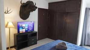 Ein Hotelzimmer mit Bett, aufgehängtem Bisonkopf, Fernseher auf einem Tisch und einem Kleiderschrank.
