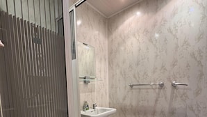 A modern bathroom with a glass shower enclosure, a white pedestal sink, a mirror, and a bathtub. - No 34 Vance Road (Blackpool)