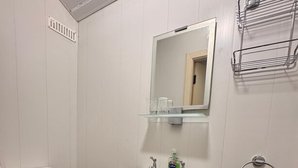 A bathroom with a toilet, sink, and mirror. - No 34 Vance Road (Blackpool)