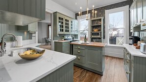 Una cocina moderna con una isla grande, electrodomésticos integrados y vistas al exterior.