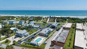 Zona residencial costera con casas, una piscina y vista al océano.