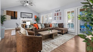A spacious living room with a large sectional sofa, a coffee table, and a dining area with a table and chairs.