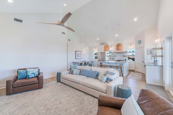 A spacious living area with a sofa, a coffee table, and a ceiling fan.