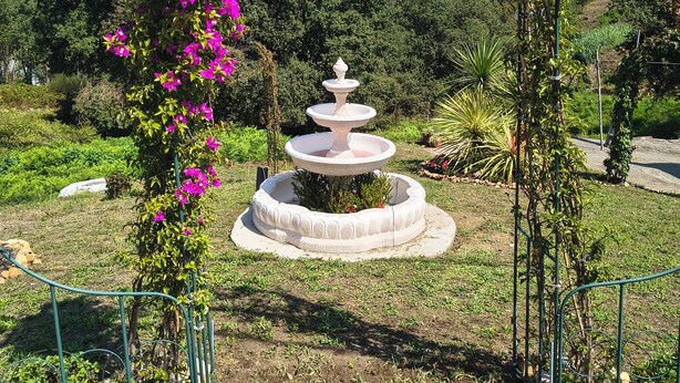 A garden with a fountain, a sign reading 'Cuquit's Garden,' and a metal archway. - Charming apartment in Vigo with views of the valley (pet friendly) (Vigo)