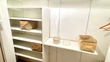 A storage closet with multiple shelves and hanging space.