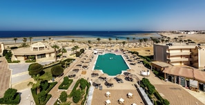 Un complexe hôtelier doté d’une piscine centrale, de plusieurs espaces de détente et offrant une vue sur la plage et l’océan.