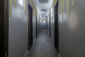 A long, narrow hallway with doors on both sides, a patterned ceiling, and a wooden floor. - Shoni Bay Resort (Marsa Alam)