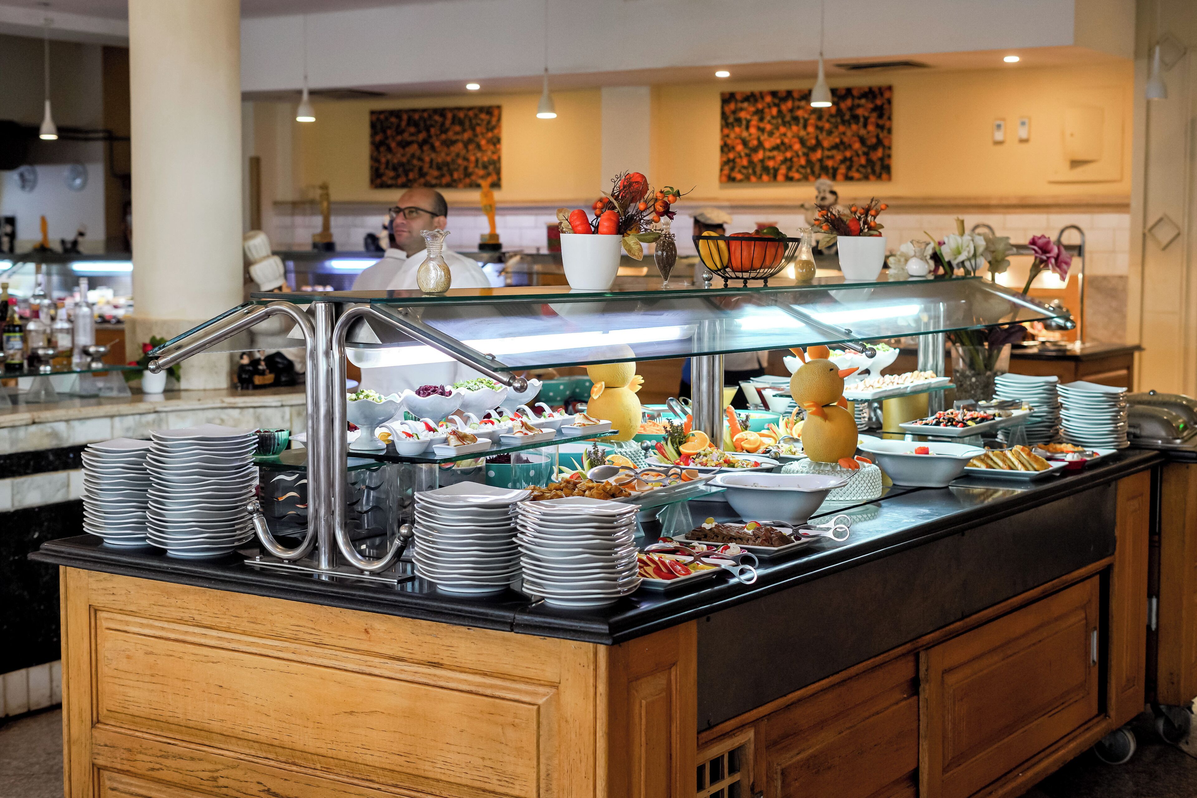 A buffet setup with various food items and a glass display case.