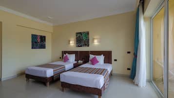 Habitación de hotel con dos camas, un cuadro en la pared y una ventana con cortinas.