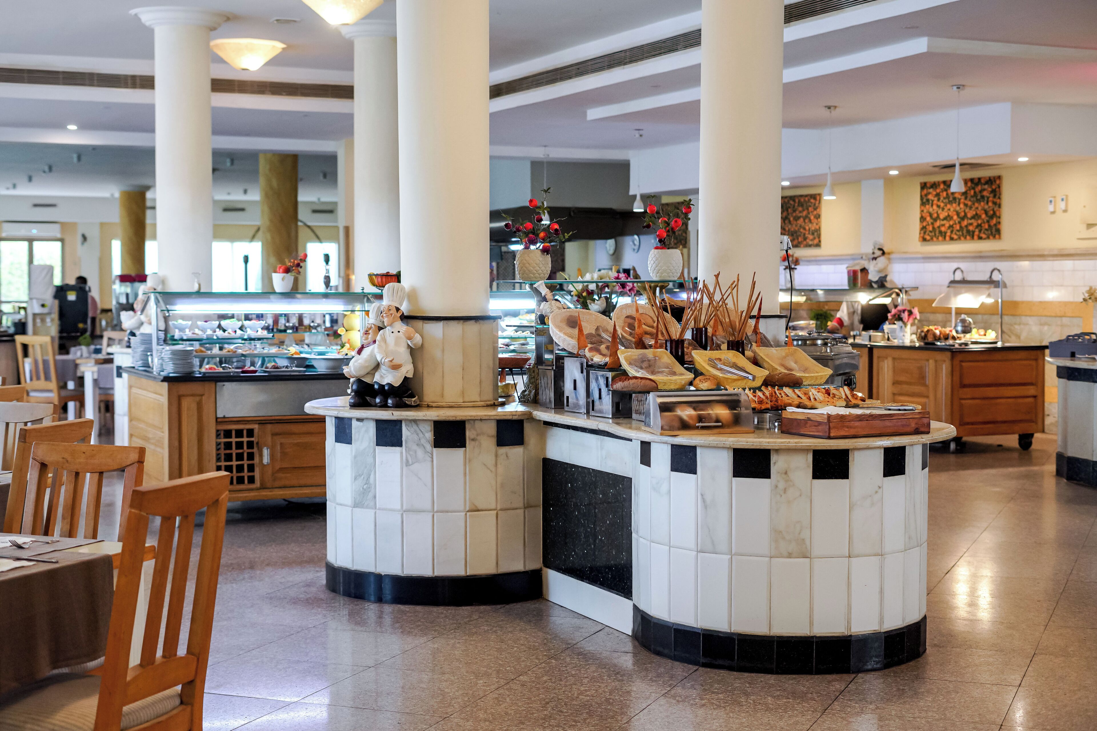 Un'area buffet con diversi cibi e una statuina di chef.