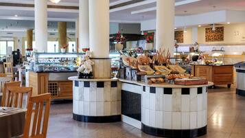 A buffet area with a variety of food items and a chef figurine.