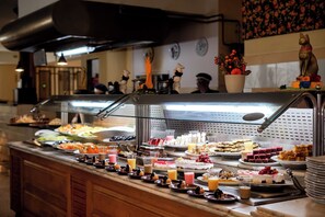 A buffet with various food items and a statue on the counter. - Shoni Bay Resort (Marsa Alam)