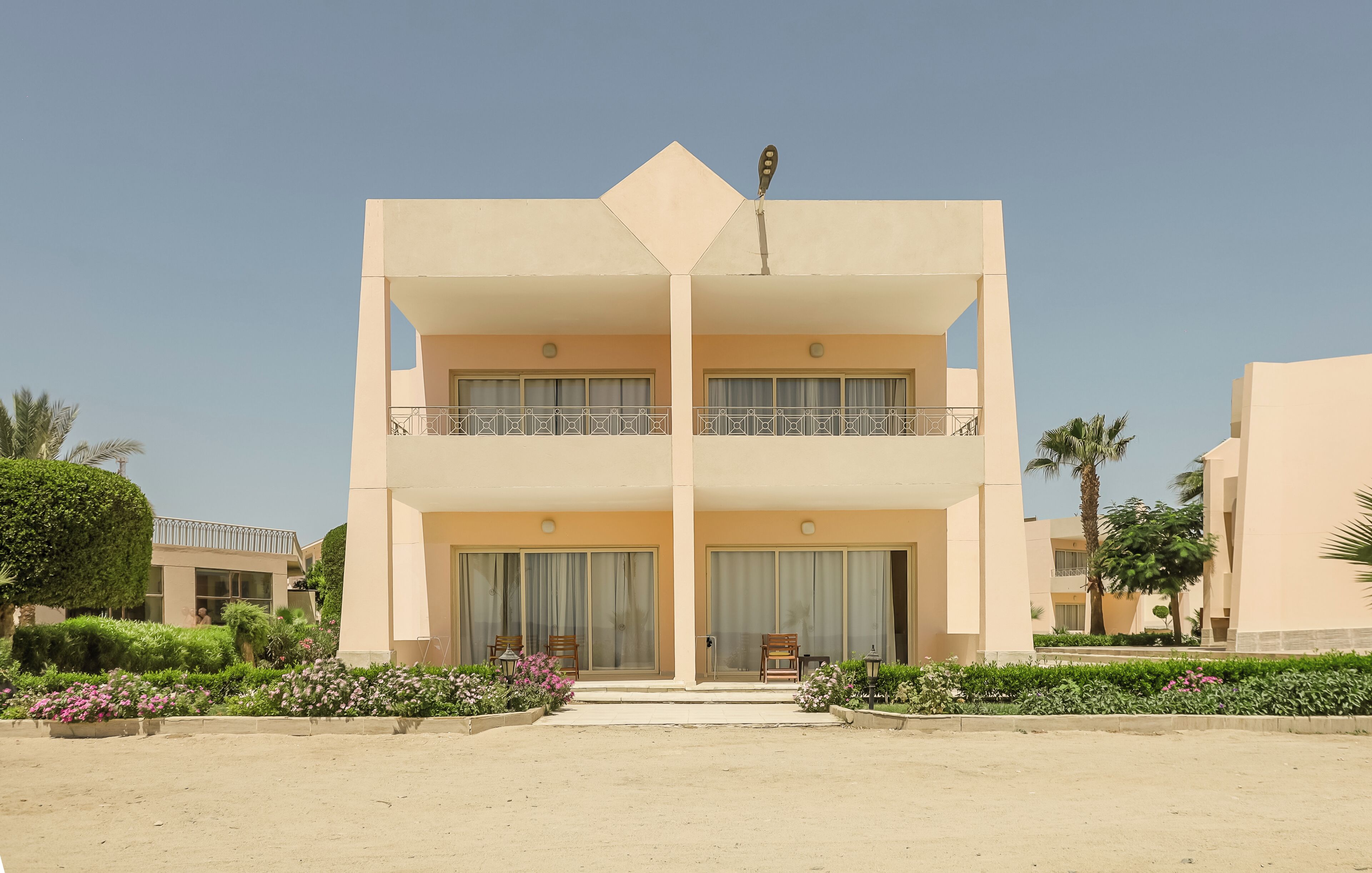 A two-story building with a central entrance, large windows, and a balcony on the upper floor.