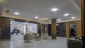 Un vestíbulo amplio con mostrador de recepción, zona de estar y acceso visible al spa.