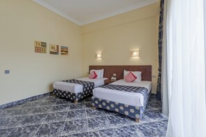 Una habitación de hotel con dos camas, piso de baldosas de mármol e iluminación empotrada en la pared.