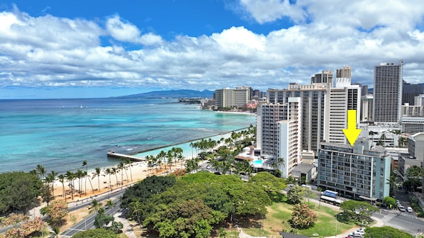 A coastal cityscape with high-rise buildings, a beach, and a clear sky. - Quiet studio in vibrant Honolulu w/ refreshing AC breeze, Pool & steps to Beach (Honolulu)