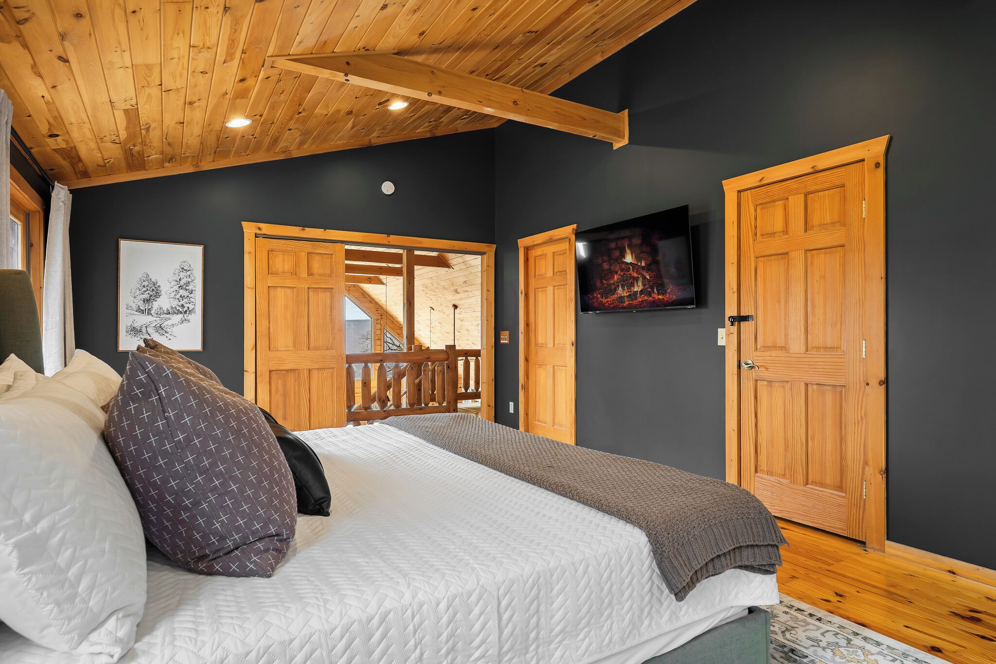 Un dormitorio con una cama, un televisor y una puerta de madera.